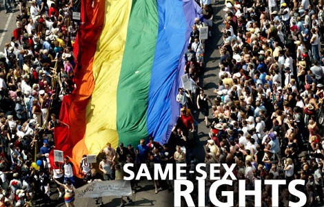 Participants caryy a giant rainbow flag during the Pride Parade on Yonge Street in Toronto Sunday June 29, 2003. The parade is the final event of Pride Week, Canada's largest gay and lesbian celebration. (CP PHOTO/Saul Porto)