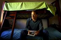 Non-custodial father Hugh Bathurst, a veteran of two marriage breakdowns,  holds photographs of his daughters.