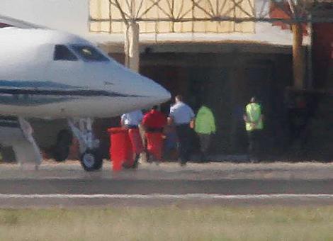 David Hicks, in orange-red overalls, is escorted from a chartered jet at Adelaide's Edinburgh Air Force Base on his way to Yalala Labour Prison to serve out his sentence.